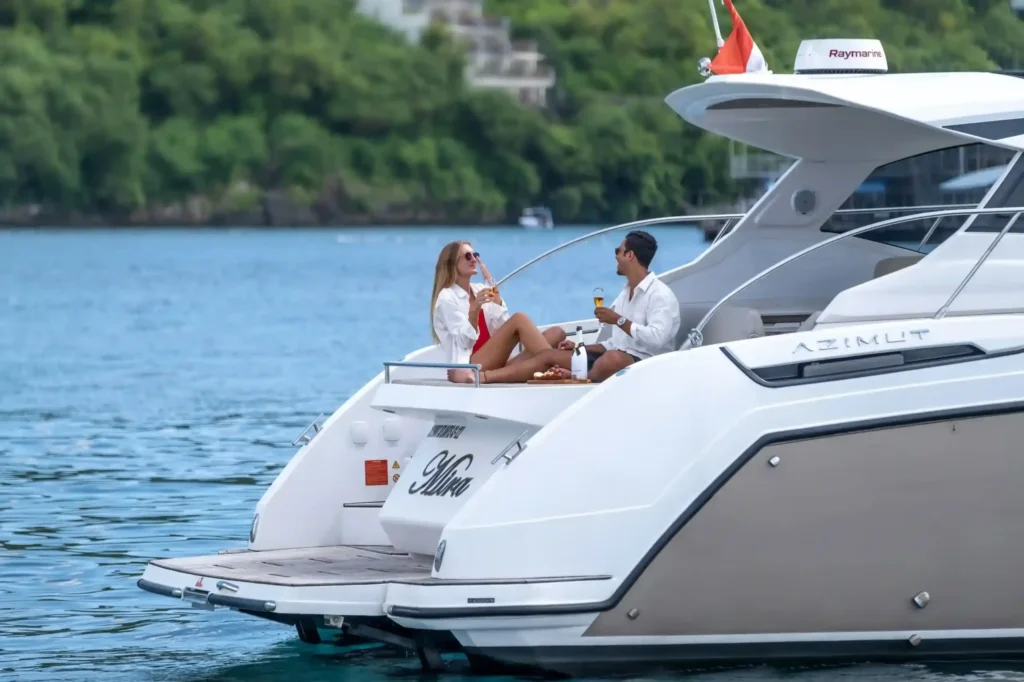 Couple with champagne on the aft deck of a private yacht, Bali